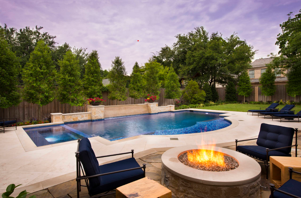 A cozy backyard featuring a warm swimming pool, a fire pit, and comfortable lounge chairs for relaxation.